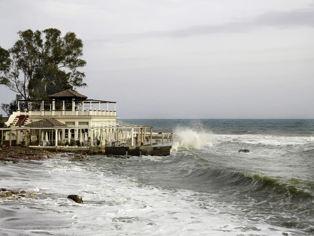 An old Balneareo at the mediterranean spanish coast with view to the sea and braking waves