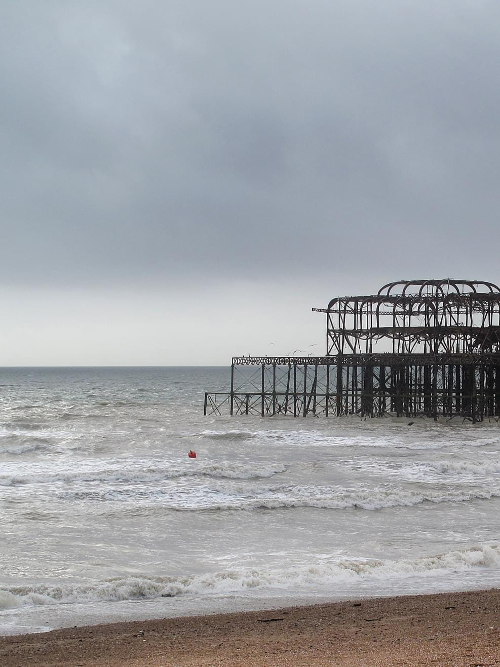 A view from the beach to Brighton West Pier on a cloudy day