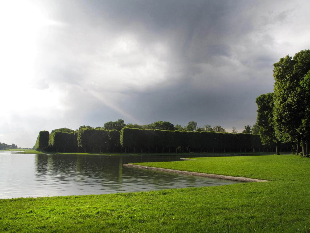 A view to the waters in the Versailles Palace Park in France on a cloudy summers day